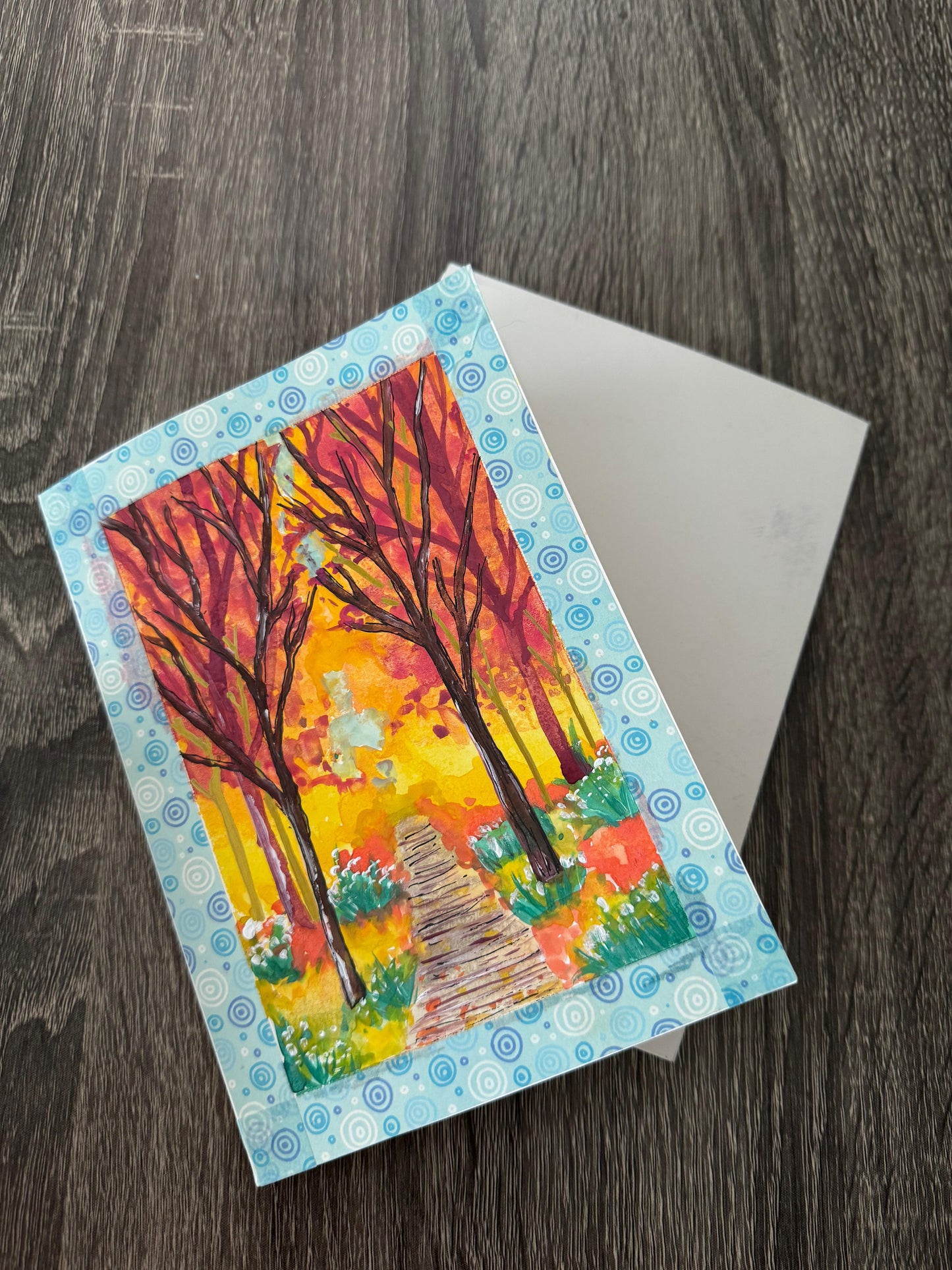 Handmade autumn pathway greeting card with vibrant fall trees and forest trail.