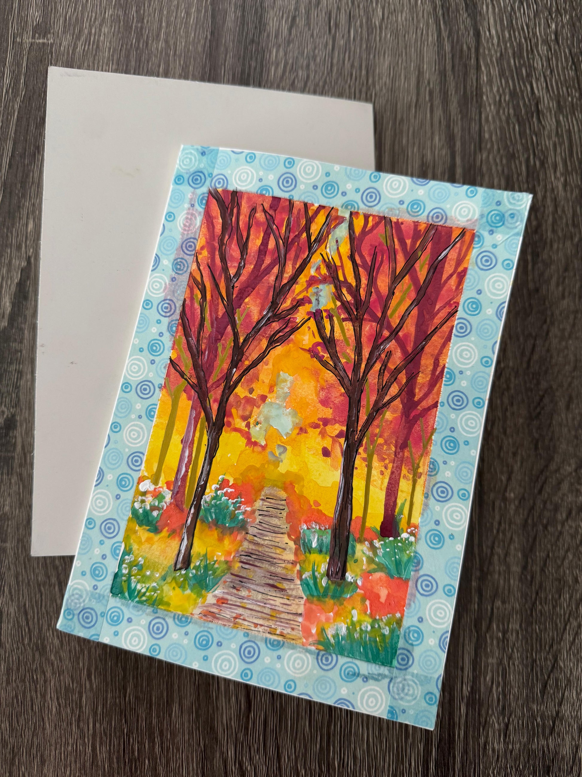 Colorful greeting card with autumn trees and a path .