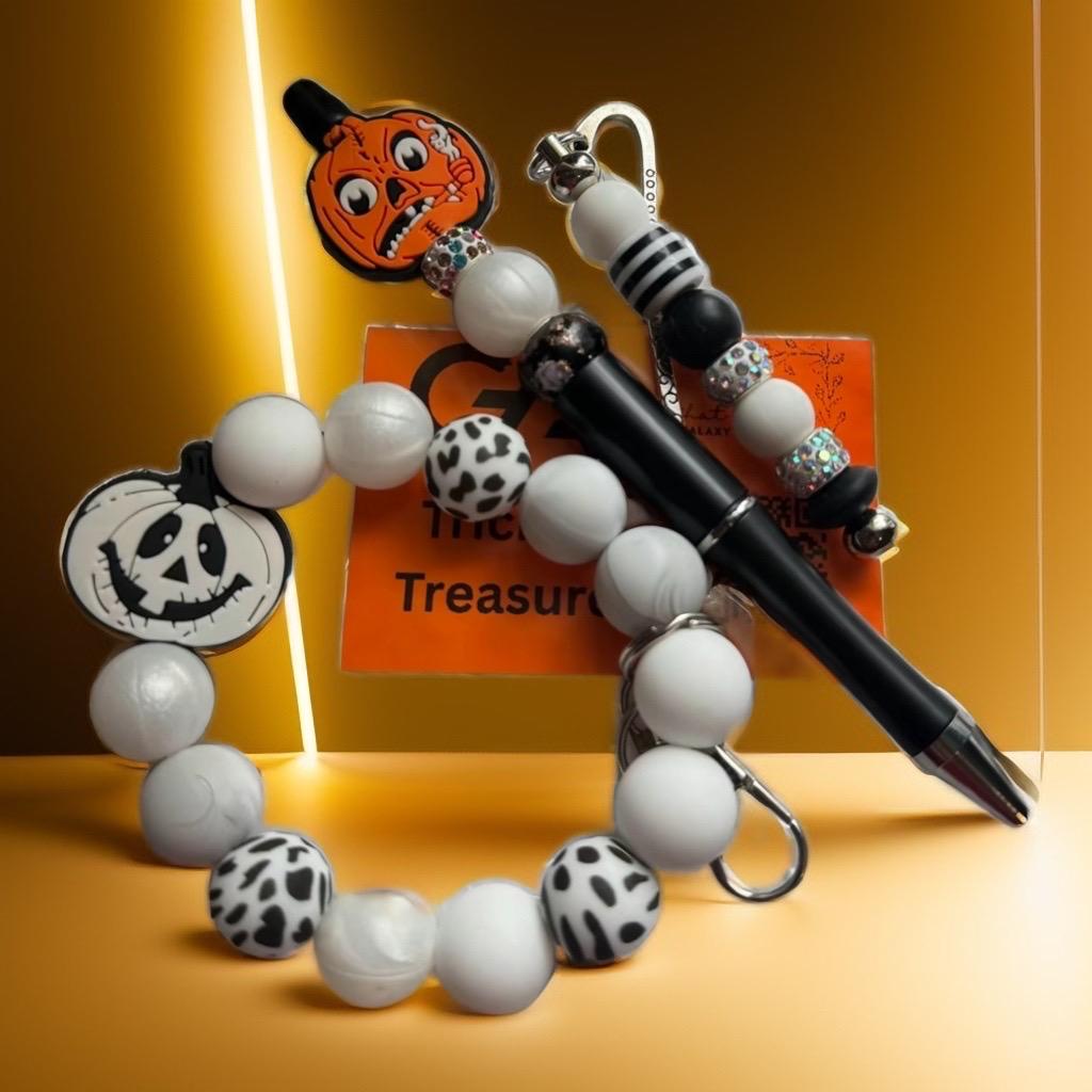 Decorative pen with Halloween-themed beads and pumpkin charm .